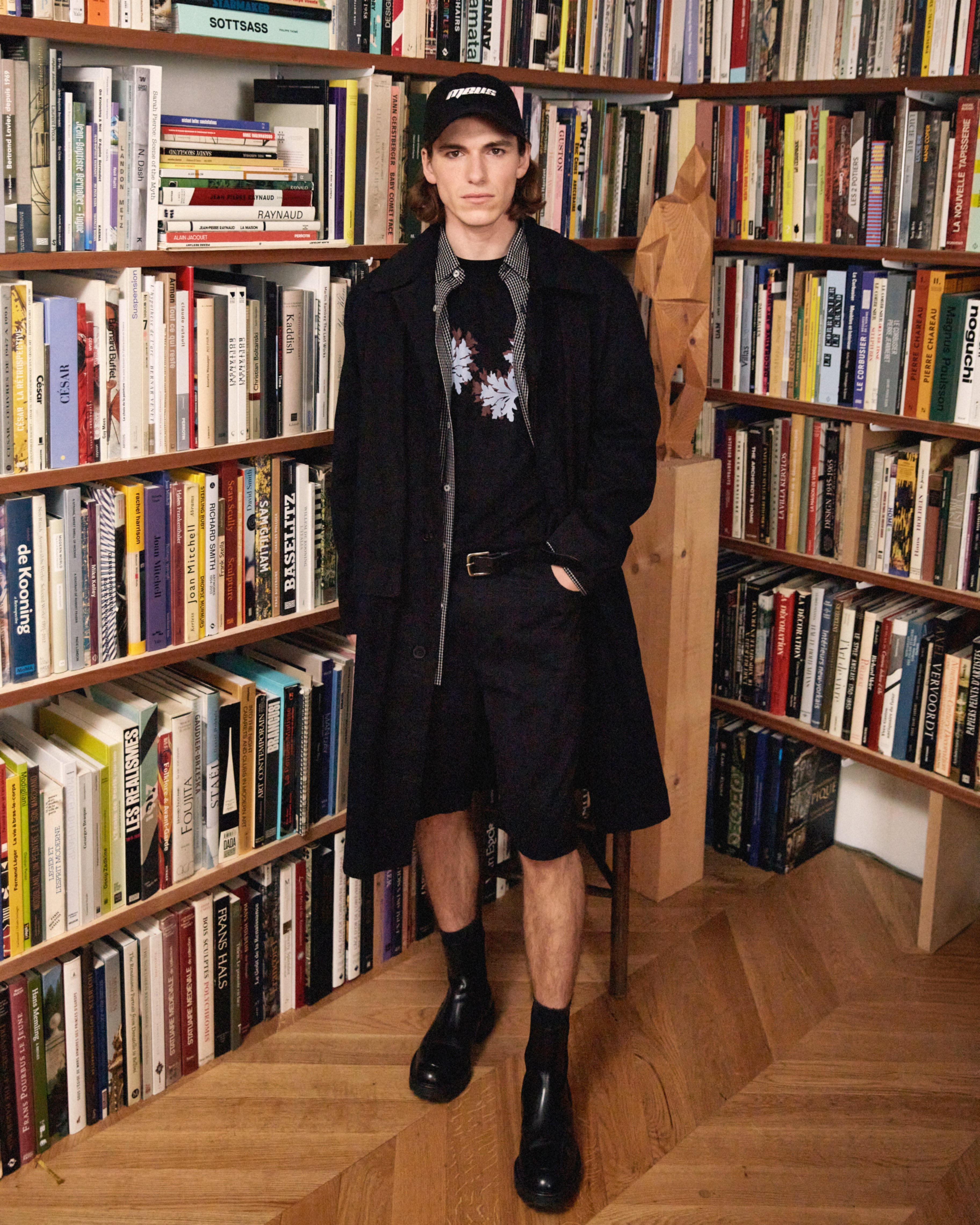 homme portant un manteau noir et un short noir meus paris 