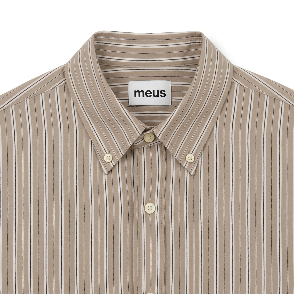 Gros plan carré du col boutonné de la chemise rayée, avec l’étiquette meus
